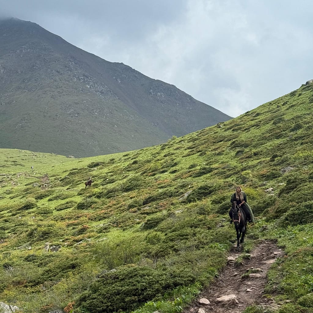Woman riding hirse down mountain from Koltor Lake