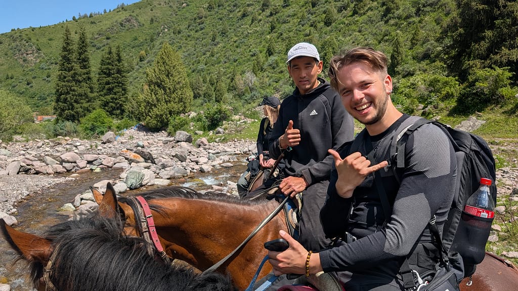 Horse guide and tourist posing for photo while horse trekking to Koltor Lake