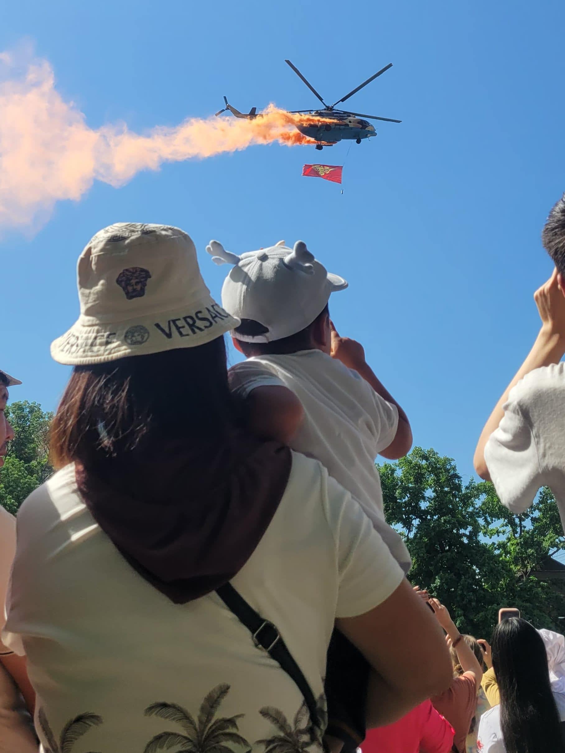 Kyrgyz flag being flown above capital by helicopter as part of a military parade