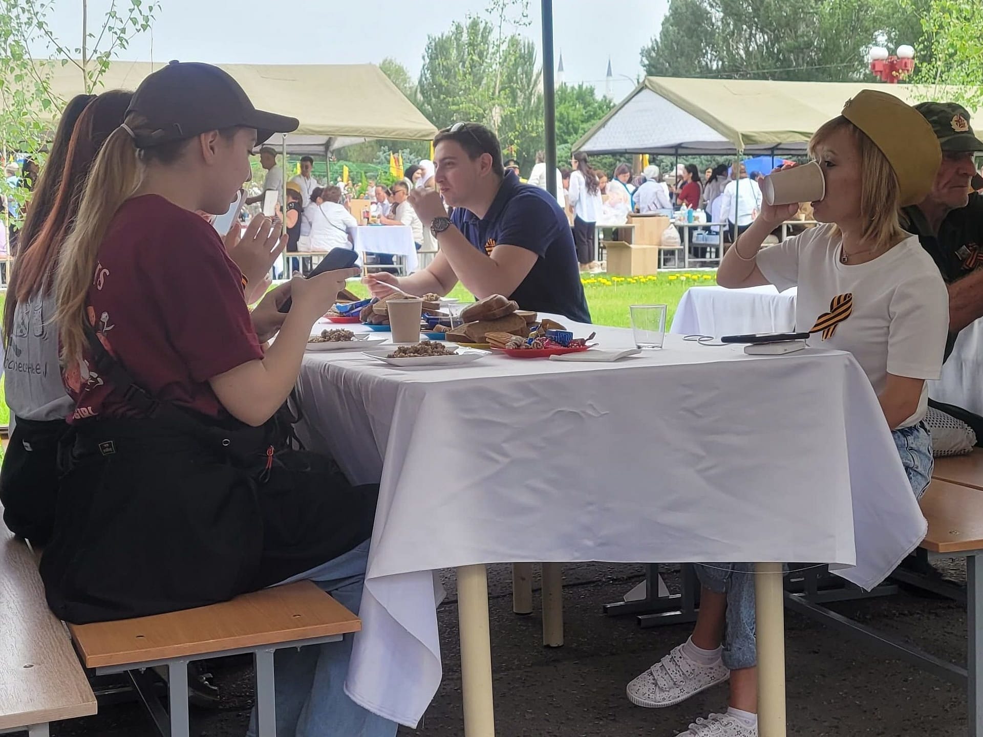 Public enjoying free food provided by government of Kyrgyzstan to celebrate Victory Day